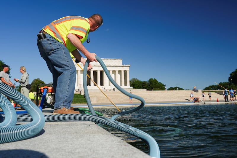 National Park Service workers push algae towards an aeration area in the center of the Lincoln Memorial Reflecting Pool following the completion of recent renovations in Washington, D.C., U.S., June 15, 2026.