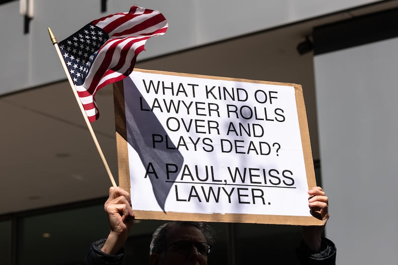 NEW YORK, NEW YORK - MARCH 25: People hold signs as they protest outside of the offices of Paul, Weiss, Rifkind, Wharton & Garrison LLP on March 25, 2025 in New York City. Activists held a protest at the law firm after the firm's managing partner Brad Karp reached a deal with the Trump administration to avoid litigation following an executive order targeting them. Karp agreed to give the Trump administration $40 million in free legal work for causes the president supports and to get rid of any internal diversity, equity and inclusion policies. (Photo by Michael M. Santiago/Getty Images)