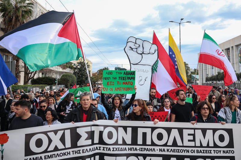 Protesters hold flags and march behind a banner reading "No to war", during an anti-war protest in conjunction with the "No Kings" protests in the United States, in front of the US embassy in Athens, Greece, March 28, 2026. REUTERS/Louisa Gouliamaki