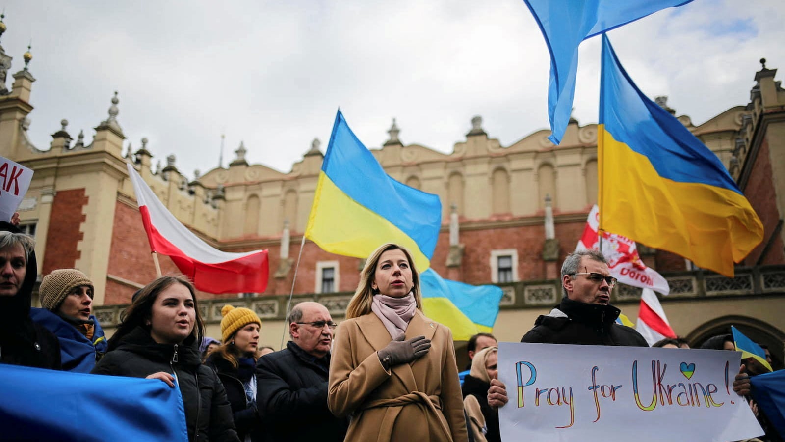 People wave Polish and Ukrainian flags during a demonstration in solidarity with Ukraine in Krakow, Poland, Feb. 20, 2022.