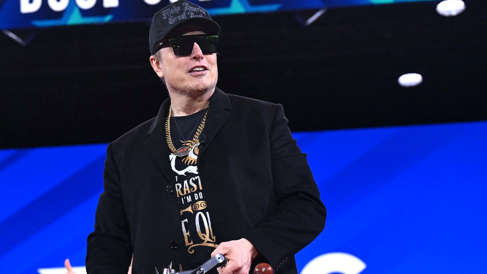 Elon Musk holds a chainsaw reading "Long live freedom, damn it" during the annual Conservative Political Action Conference (CPAC) at the Gaylord National Resort & Convention Center at National Harbor in Oxon Hill, Maryland.