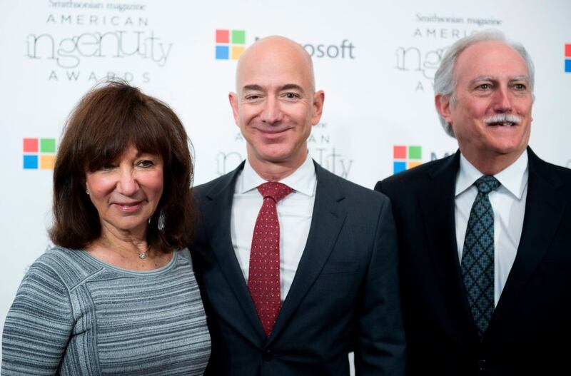 Amazon CEO Jeff Bezos poses on the red carpet with his parents Mike and Jackie, for the Smithsonian Magazine's 2016 American Ingenuity Awards, honoring groundbreaking individuals in several categories, at the National Portrait Gallery on December 8, 2016 in Washington, DC. - Amazon CEO Jeff Bezos received the Technology award for  his historic achievement in aviation and space exploration. (Photo by MOLLY RILEY / AFP) (Photo by MOLLY RILEY/AFP via Getty Images)
