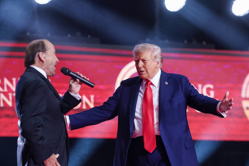 GLENDALE, ARIZONA - SEPTEMBER 21: U.S. President Donald Trump goes to embrace singer Lee Greenwood during the memorial service for political activist Charlie Kirk at State Farm Stadium on September 21, 2025 in Glendale, Arizona.