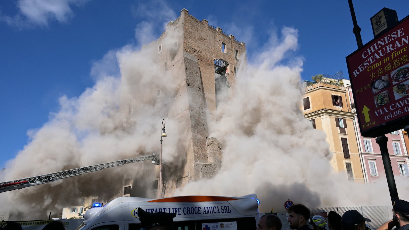 TOPSHOT - Dust rises due to a second collapse of part of the medieval tower "Torre dei Conti" near the Roman Forum in the historic center of Rome on November 3, 2025. (Photo by Tiziana FABI / AFP) (Photo by TIZIANA FABI/AFP via Getty Images)