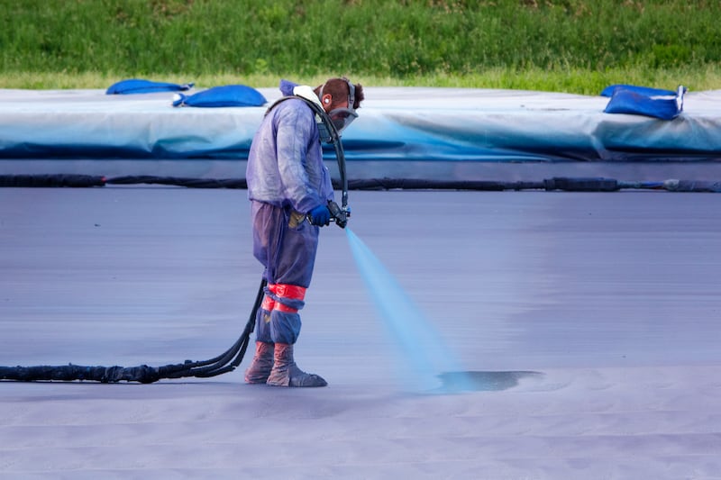 A worker sprays blue paint onto the bottom of the Lincoln Memorial Reflecting Pool on the National Mall on May 28, 2026 in Washington, DC. The project is in preparation for the country's 250th birthday celebration this summer.