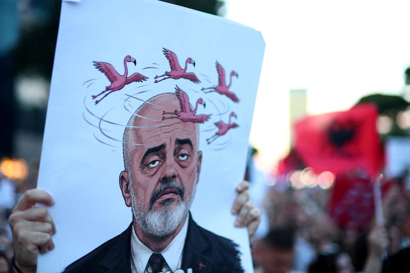 A protester holds a sign depicting Albanian Prime Minister Edi Rama during a protest against a luxury resort plan by a company linked to Donald Trump's son-in-law, Jared Kushner, on an environmentally sensitive part of the Adriatic coast, in Tirana, Albania, June 5, 2026. REUTERS/Florion Goga