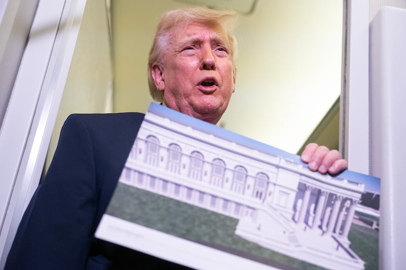 Trump holds a rendering of the proposed East Wing of the White House. Photo by Nathan Howard/Getty Images.