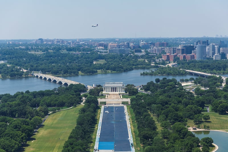 FILE PHOTO: A commercial aircraft flies above, as workers paint the Lincoln Memorial Reflecting Pool blue at the directive of U.S. President Donald Trump on the National Mall in Washington, D.C., U.S, May 18, 2026. Reuters/Tom Brenner/File Photo