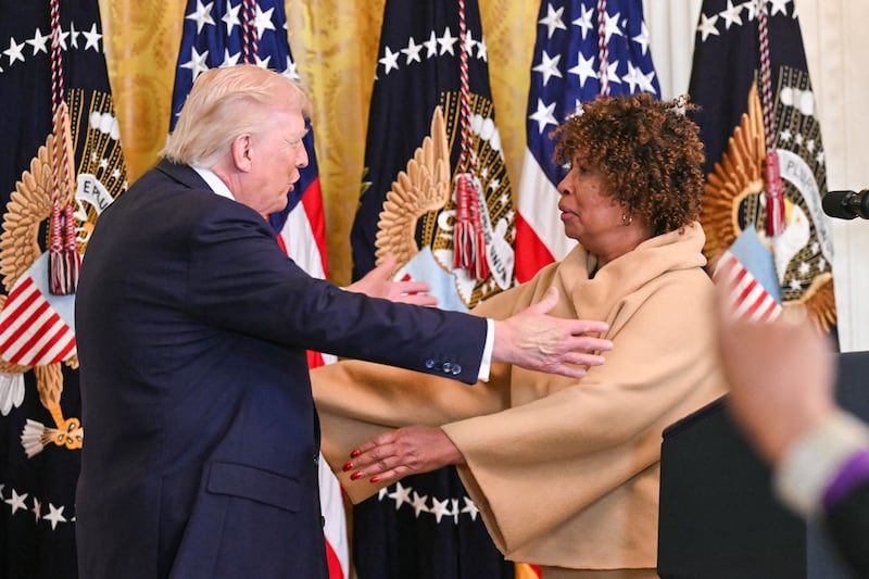 (L/R) US President Donald Trump embraces Forlesia Cook, whose grandson was murdered in Washington, DC, in 2017, during a Black History Month event in the East Room of the White House in Washington, DC, on February 18, 2026. (Photo by SAUL LOEB / AFP via Getty Images)