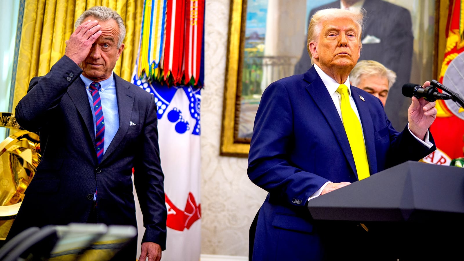 U.S. President Donald Trump, accompanied by Health and Human Services Secretary Robert F. Kennedy Jr. (L), takes a question