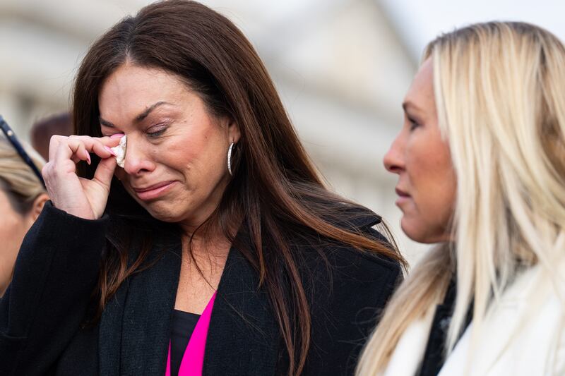 Haley Robson, who says she was assaulted by Jeffrey Epstein when she was 16, wipes away tears while standing alongside Rep. Marjorie Taylor Greene during the news conference outside the U.S. Capitol on Tuesday, November 18, 2025 ahead of a vote on the bill to release the files.
