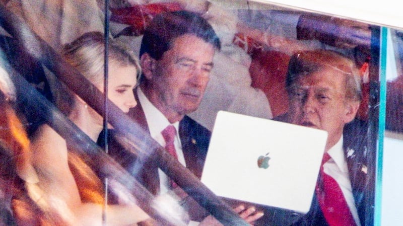 Donald Trump's constant companion Natalie Harp shows something to the president on her laptop at the Tennessee vs. Texas college football game in Knoxville.