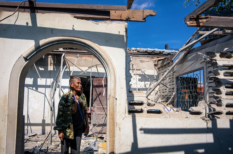 A resident shows part of a house, believed to have been damaged by Cambodian artillery shells during clashes, along the Thai-Cambodia border in Thailand's Sa Kaeo Province on December 9, 2025.