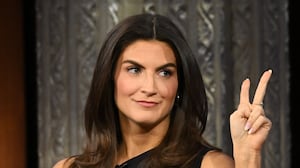 Kaitlan Collins appears to flash a victory sign at Stephen Colbert.