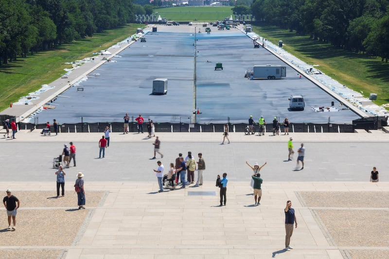 Visitors walk past the Lincoln Memorial Reflecting Pool as construction workers paint it blue at the directive of U.S. President Donald Trump on the National Mall in Washington, D.C., U.S, May 18, 2026. REUTERS/Tom Brenner