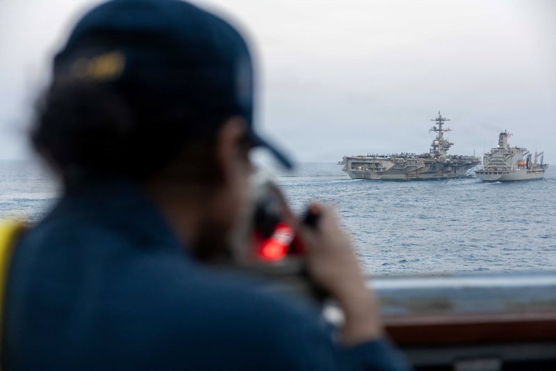 A U.S. Navy sailor looks out as Nimitz-class aircraft carrier USS Abraham Lincoln
