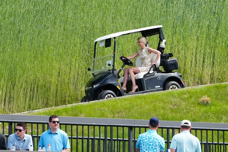 Natalie Harp, executive assistant to US President Donald Trump drives a golf cart as she arrives at Trump National Golf Club.