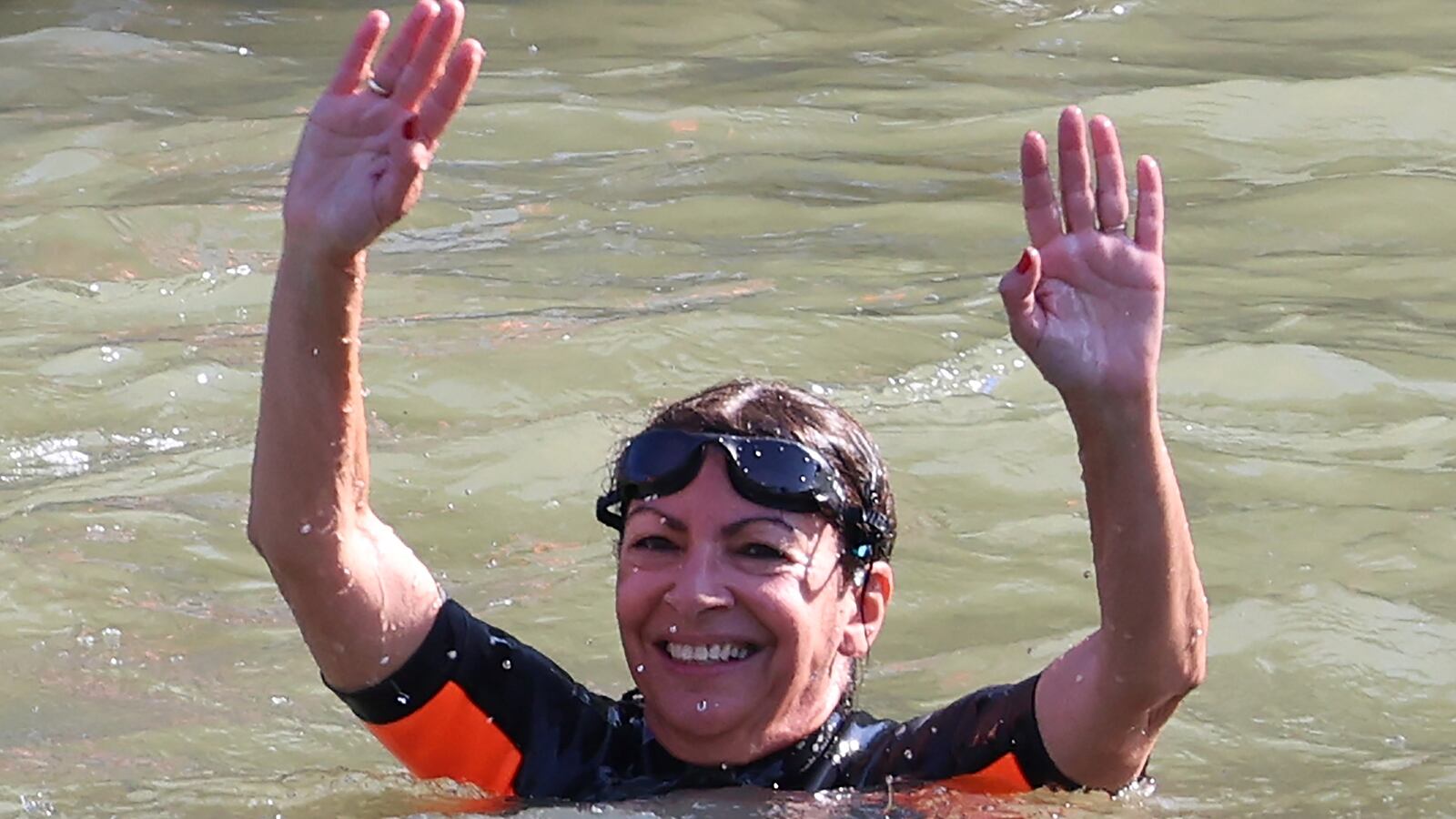 Paris Mayor Anne Hidalgo (R) swims in the Seine River, in Paris on July 17, 2024, to demonstrate that the river is clean enough to host the outdoor swimming events at the Paris Olympics.