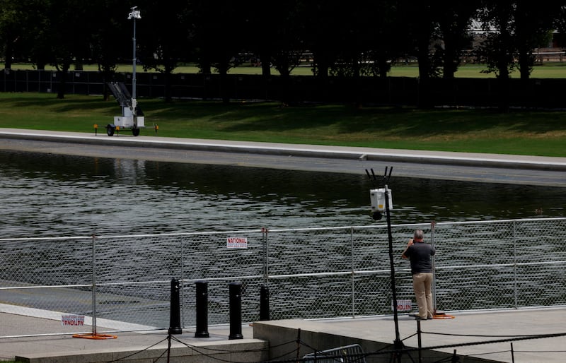 A person observes the Lincoln Memorial Reflecting Pool through a fence as its draining continues, following renovations and Independence Day celebrations, in Washington, D.C., U.S., July 12, 2026. REUTERS/Leah Millis