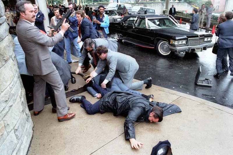 White House Press Secretary James Brady and police officer Thomas Delahanty lie wounded on the ground after John Hinckley Jr. fired six shots at President Ronald Reagan outside the Washington Hilton Hotel in Washington, DC, U.S. on March 30, 1981.