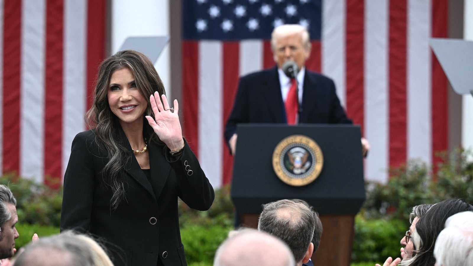 US Secretary of Homeland Security Kristi Noem waves after being acknowledged by US President Donald Trump as he delivers remarks on reciprocal tariffs during an event in the Rose Garden entitled "Make America Wealthy Again" at the White House in Washington, DC, on April 2, 2025. Trump geared up to unveil sweeping new "Liberation Day" tariffs in a move that threatens to ignite a devastating global trade war. Key US trading partners including the European Union and Britain said they were preparing their responses to Trump's escalation, as nervous markets fell in Europe and America. (Photo by Brendan SMIALOWSKI / AFP) (Photo by BRENDAN SMIALOWSKI/AFP via Getty Images)