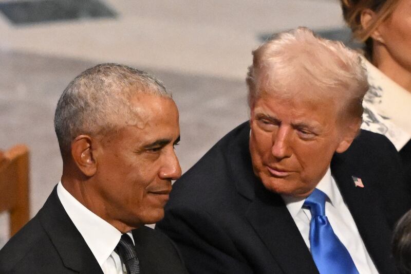 Donald Trump speaks with former President Barack Obama as they attend the State Funeral Service for former US President Jimmy Carter at the Washington National Cathedral in Washington, DC,