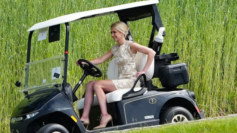 Natalie Harp, executive assistant to US President Donald Trump drives a golf cart as she arrives at Trump National Golf Club.