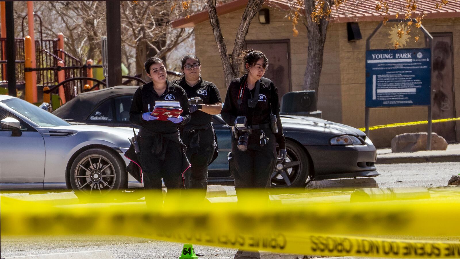 Crime scene technicians investigate the parking lot at Young Park after Friday night's fatal shooting in Las Cruces, N.M., on Saturday, March 22, 2025. (Chancey Bush/The Albuquerque Journal via AP)