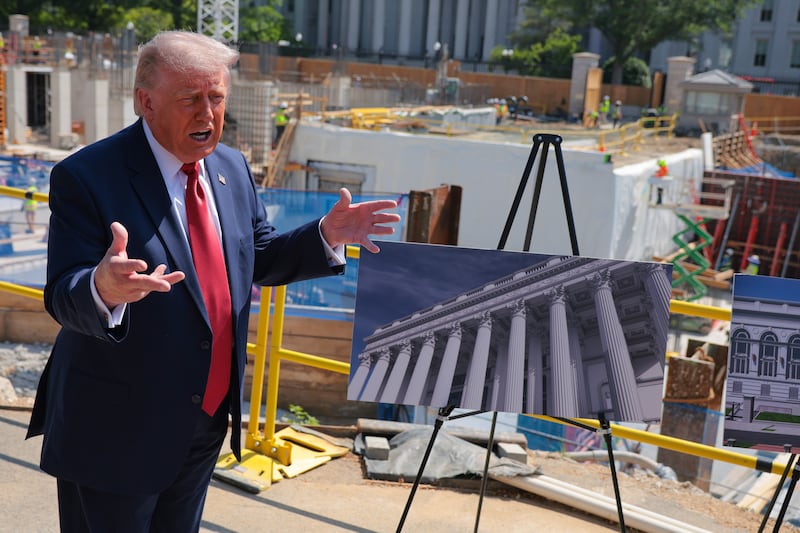 President Donald Trump speaks to the media alongside posters of his proposed White House ballroom amid construction at the White House on May 19, 2026.