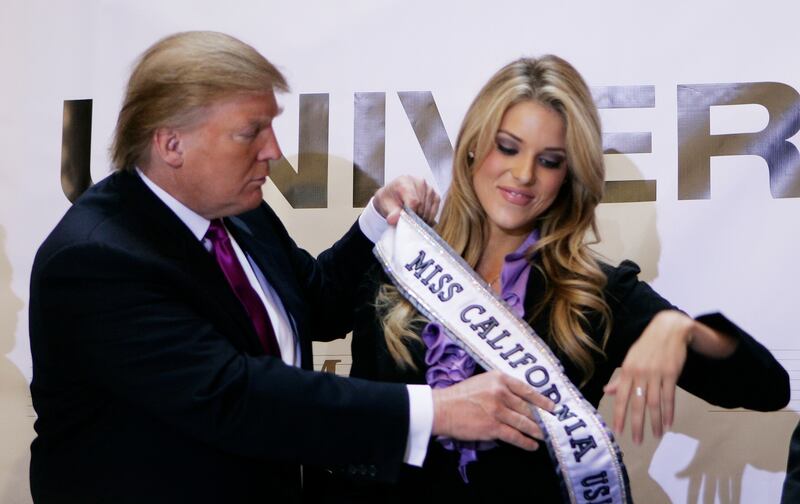 Donald Trump, the owner of the Miss Universe Organization, gives Miss California USA, Carrie Prejean, her sash during a news conference in New York May 12, 2009.