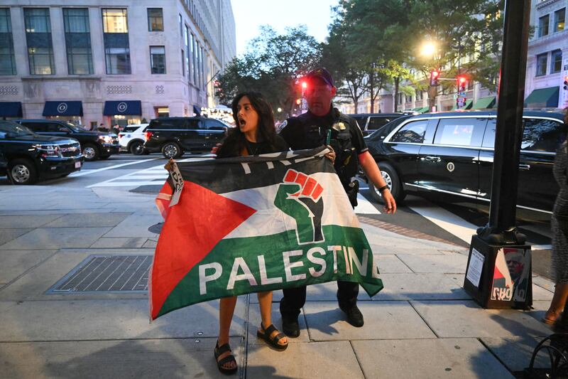 Police remove a pro-Palestinian protester from Joe's Seafood, Prime Steak & Stone Crab as the US president arrived to dine there in Washington, DC, on September 9, 2025. (Photo by SAUL LOEB / AFP) (Photo by SAUL LOEB/AFP via Getty Images)