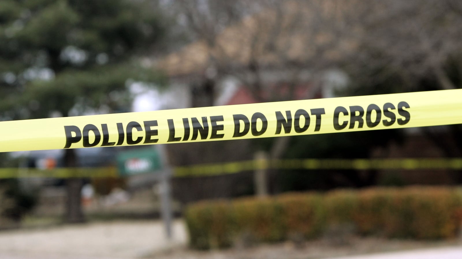 Police tape hangs across the street.