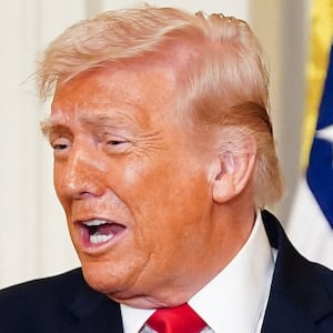 U.S. President Donald Trump reacts as bobsledder Kaillie Humphries gives him the Order of Ikkos during a Women's History Month event, in the East Room of the White House in Washington, D.C., U.S. March 12, 2026. REUTERS/Nathan Howard