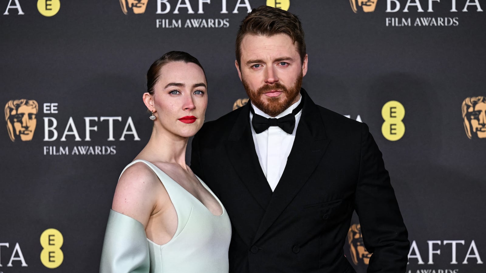 US-Irish actor Saoirse Ronan and Scottish actor Jack Lowden (R) pose on the red carpet upon arrival at the BAFTA British Academy Film Awards at the Royal Festival Hall, Southbank Centre, in London, on February 16, 2025.