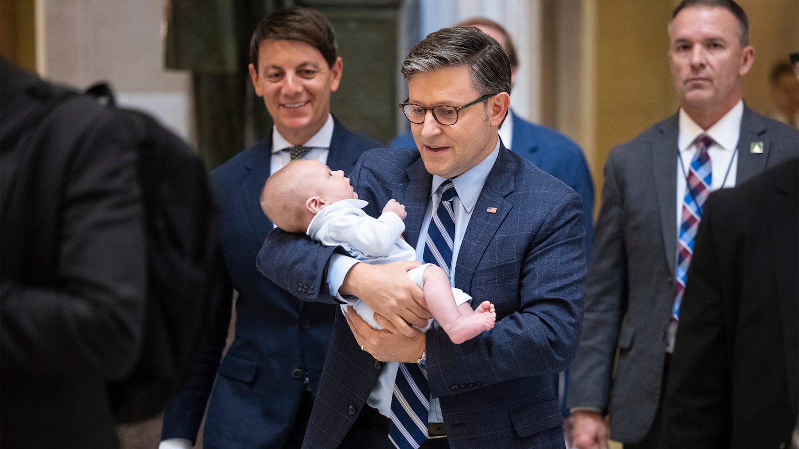 House Speaker Mike Johnson (R-La.) holds the infant son of his chief of staff as he walks to a vote at the U.S. Capitol June 5, 2025.