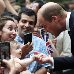 8 month old Albane Costa holds the finger of Prince William, Prince of Wales during his visit to the HSBC Rain Vortex at Jewel Changi Airport on day one of his visit to Singapore