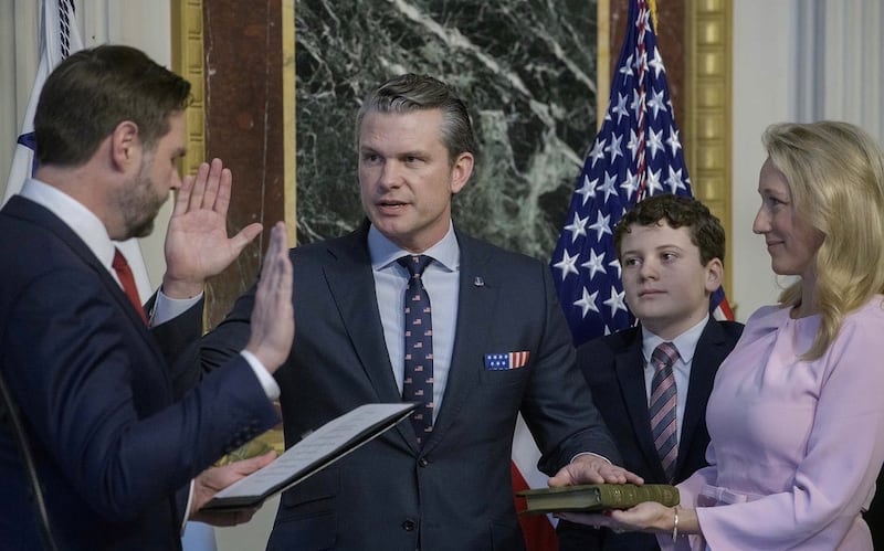 JD Vance swears in Pete Hegseth, while his wife Jennifer holds the Bible.