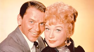 Frank Sinatra (1915-1998), US singer and actor, and Shirley MacLaine , US actress, pose for a studio portrait, against a yellow background, issued for the film, 'Can-Can', 1960. (Photo by Silver Screen Collection/Getty Images)