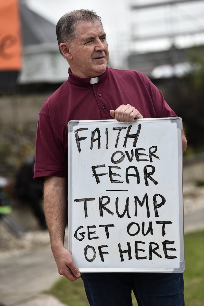 A member of the clergy holds an anti-Trump message, as demonstrators hold a protest against U.S. President Donald Trump's visit to Doonbeg, Ireland, and U.S. support for Israel in the conflict with the Palestinians, September 13, 2026. REUTERS/Natalia Campos