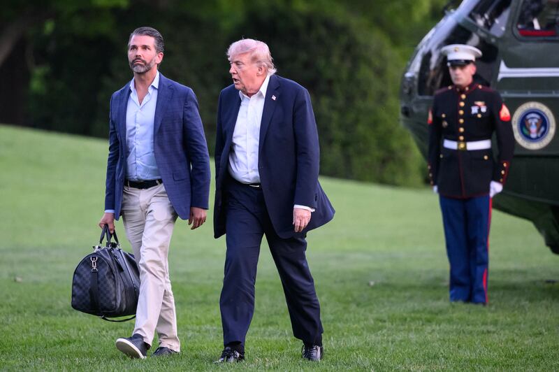 President Donald Trump and Donald Trump Jr. walk on the south lawn toward the White House in Washington, DC, on May 3, 2026.