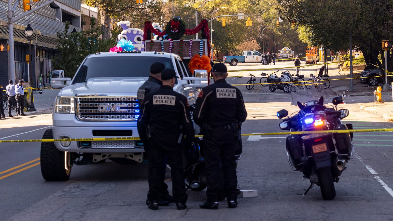 Police officers work the scene after a truck pulling a float crashed at a holiday parade in Raleigh, N.C., on Saturday, Nov. 19, 2022.