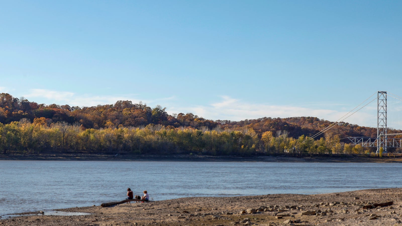 People sit along the banks of the Mississippi River, which has seen record low water levels, in Grand Tower, Illinois