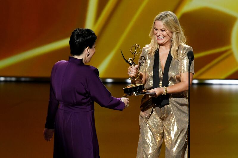 LOS ANGELES, CALIFORNIA - SEPTEMBER 22: Alex Borstein accepts the Outstanding Supporting Actress in a Comedy Series award for 'The Marvelous Mrs. Maisel' from Amy Poehler onstage during the 71st Emmy Awards at Microsoft Theater on September 22, 2019 in Los Angeles, California. (Photo by Kevin Winter/Getty Images)