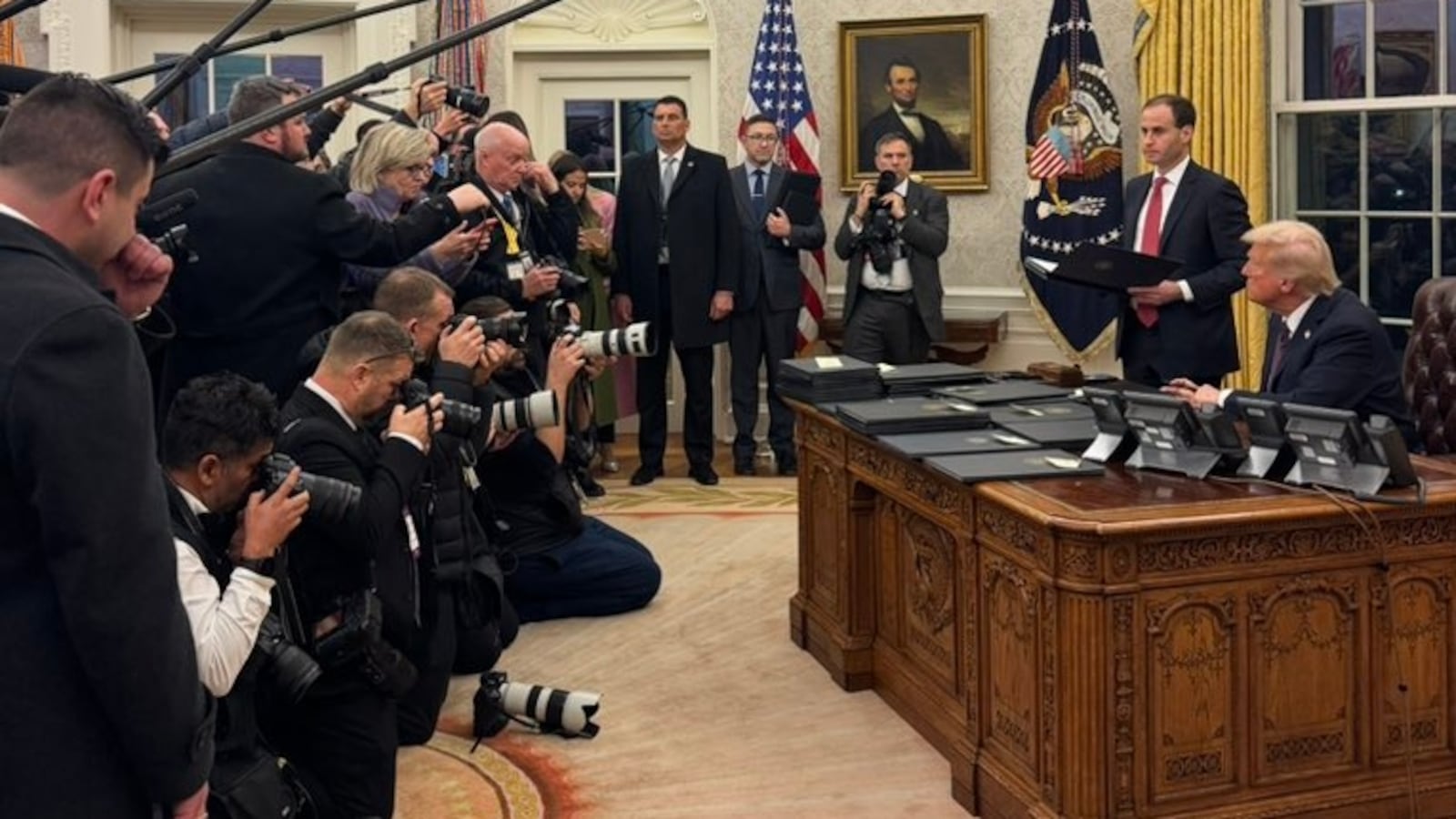 Donald Trump in Oval Office with reporters.