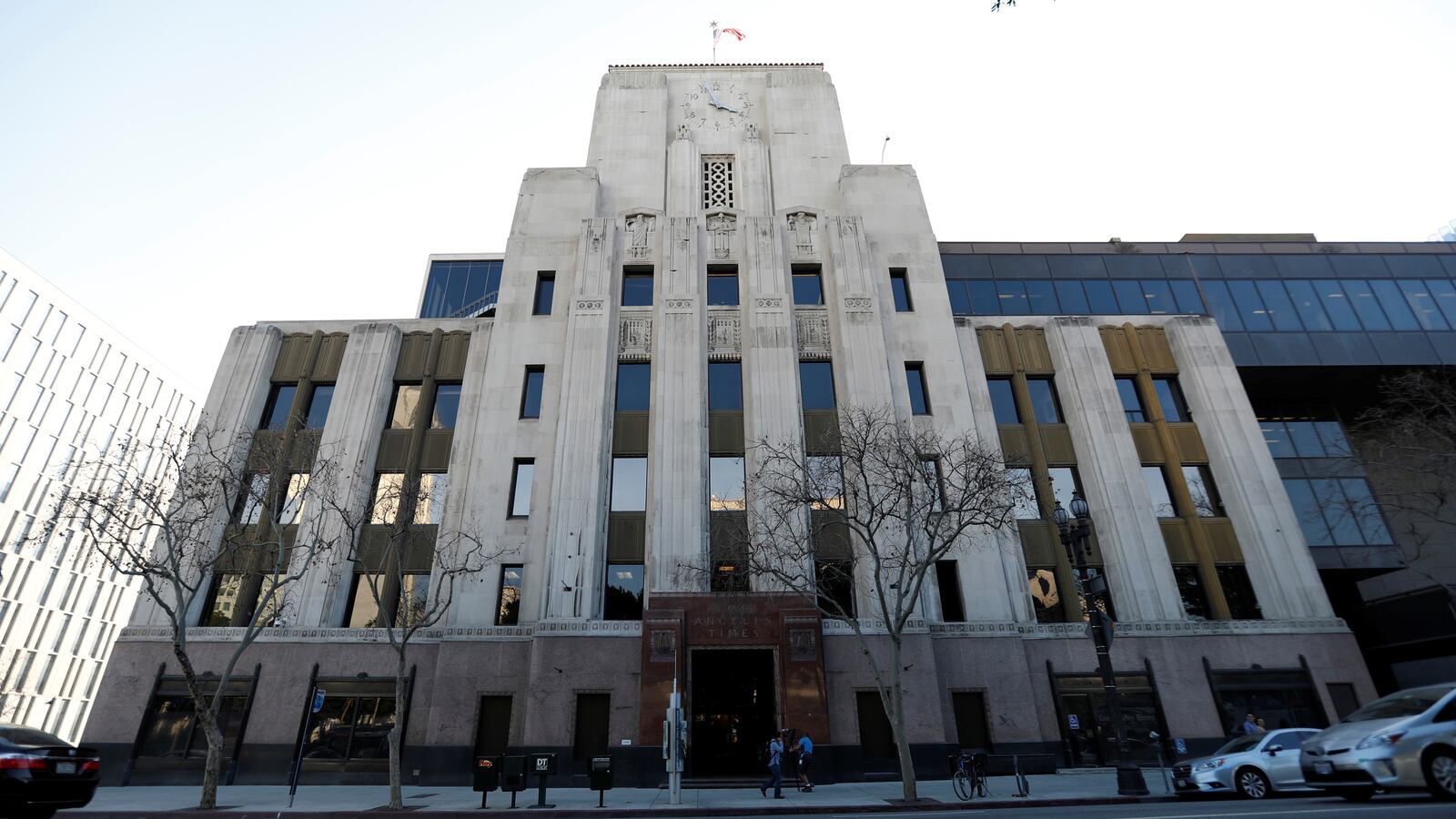 People walk in front of the Los Angeles Times building.