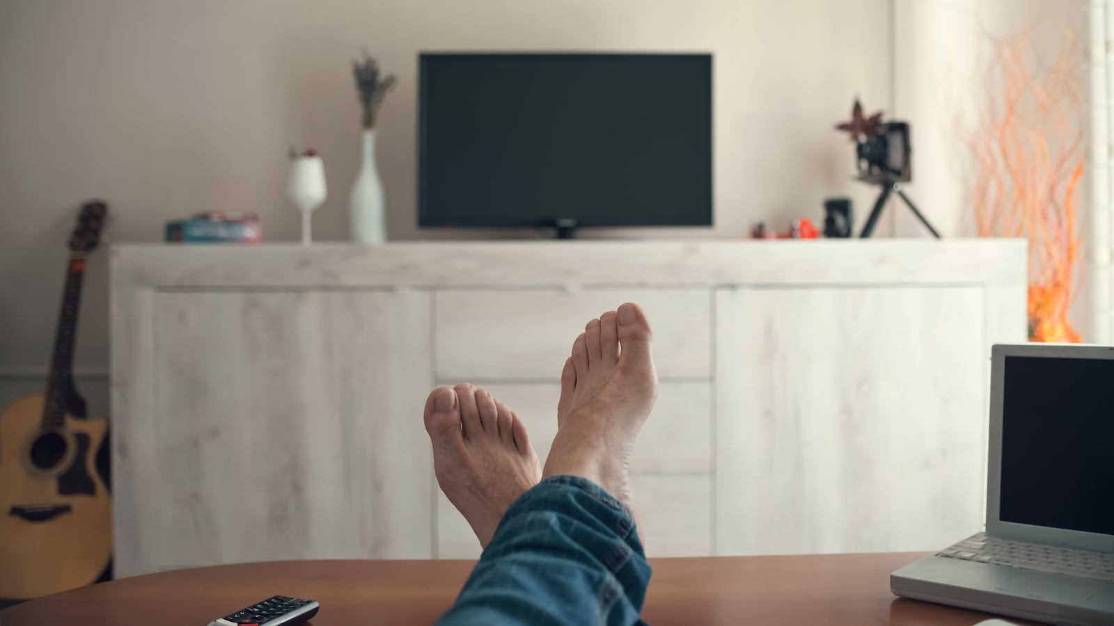 Man relaxing with feet up watching TV.