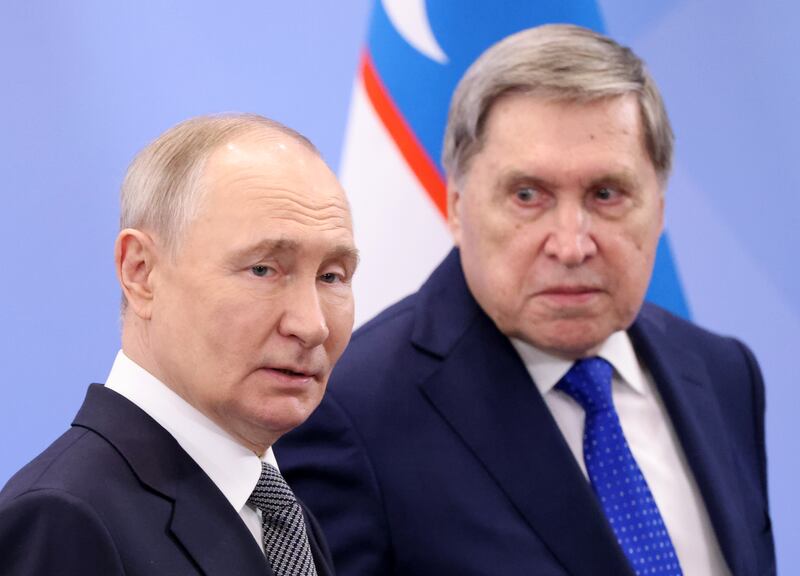 Russian President Vladimir Putin (L) talks to his aide Yuri Ushakov (R)