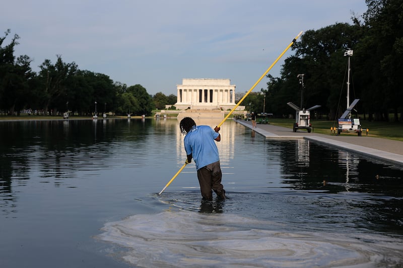 Workers clean the Lincoln Memorial Reflecting Pool on the National Mall on June 25, 2026 in Washington, DC as the Trump administration claims the pool was sabotaged but has provided scant evidence to support their vandalism accusations.