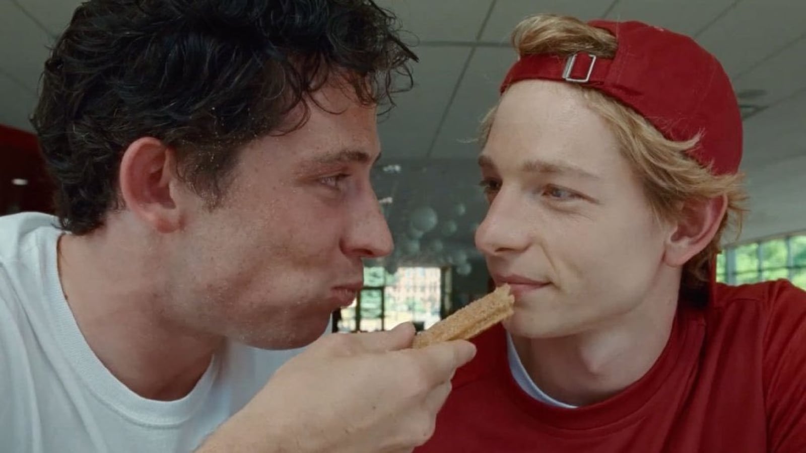 A photo still of Josh O'Connor and Mike Faist eating a churro in 'Challengers'