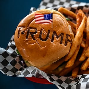 TOPSHOT - A burger is seen at Trump Burger restaurant, in Bellville, Texas, on April 19, 2025. It is lunchtime at a Texas eatery called Trump Burger and diners are enjoying fast food and the frenetic first 100 days of their president's second term. Trump is everywhere in this joint with a dozen tables -- in cardboard cutouts of the man eking out his trademark forced smile, on banners from the 2024 campaign, and on hats and T-shirts displayed for sale. It is a franchise of a company with four such Trump-themed outlets in Texas and no equal anywhere else in America. The chain is not linked to the Trump Organization. (Photo by RONALDO SCHEMIDT / AFP) (Photo by RONALDO SCHEMIDT/AFP via Getty Images)